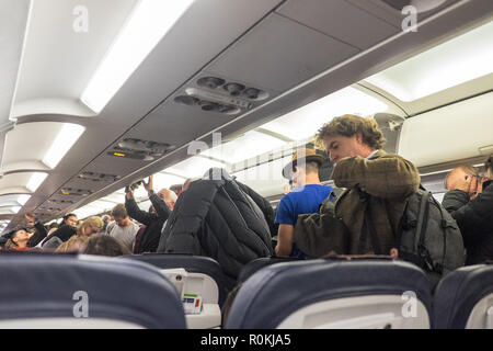 Passagiere, die darauf warten, zu, aussteigen, und, Ihre, Gepäck, aus, Overhead, Fächer, an, Brüssel, Flughafen, nach, Ankunft, ein, eine, Brussels Airlines, Flug, Stockfoto