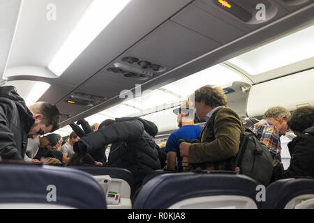 Passagiere, die darauf warten, zu, aussteigen, und, Ihre, Gepäck, aus, Overhead, Fächer, an, Brüssel, Flughafen, nach, Ankunft, ein, eine, Brussels Airlines, Flug, Stockfoto