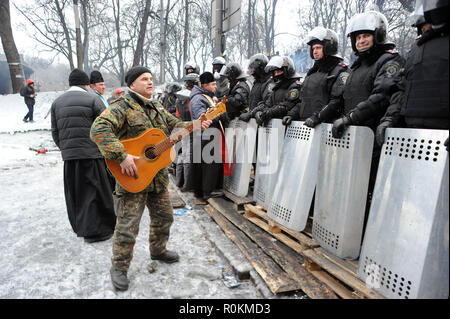 Januar 28, 2014 - Kiew, Ukraine: ein Demonstrant spielt Gitarre vor Polizisten bewachen das Parlament als einem angespannten Patt zwischen Maidan Demonstranten und Polizei weiter. Un-manifestant Joue de la Gitarre pour l'detendre Atmosphäre devant une Rangee de polciiers Anti-emeute Pres de la Place Maidan ein Kiew. *** Frankreich/KEINE VERKÄUFE IN DEN FRANZÖSISCHEN MEDIEN *** Stockfoto