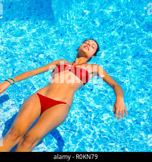Junge Frau mit roten Bikini schwimmt auf Wasser im Schwimmbad, Guadeloupe, Französisch Westindien, Stockfoto
