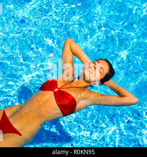 Junge Frau mit roten Bikini schwimmt auf Wasser im Schwimmbad, Guadeloupe, Französisch Westindien, Stockfoto