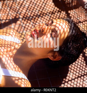 Schlafende junge Frau Porträt, Nickerchen, Flechtwerk sripes Schatten Muster, Guadeloupe, Französisch Westindien, Stockfoto