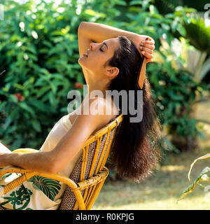 Junge Frau ihr Haar bürsten, tropischen Garten, Guadeloupe, Französisch Westindien, Stockfoto