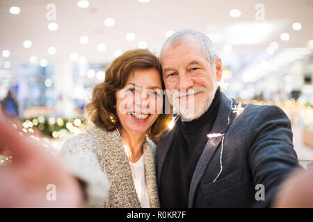 Senior Paar unter selfie im Einkaufszentrum zur Weihnachtszeit. Stockfoto