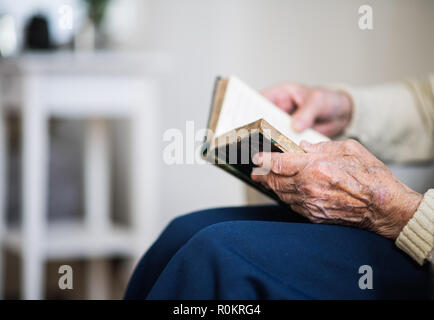 Eine Nahaufnahme der älteren Frau Lesen der Bibel zu Hause. Stockfoto