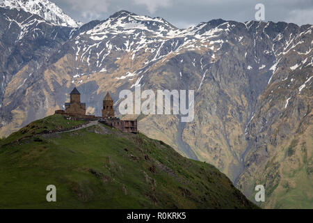 Gergeti Kirche drastisch thront auf einem Hügel im Kaukasus, in Kazbegi, Georgia. Stockfoto