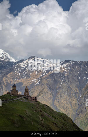 Gergeti Kirche drastisch thront auf einem Hügel im Kaukasus, in Kazbegi, Georgia. Stockfoto