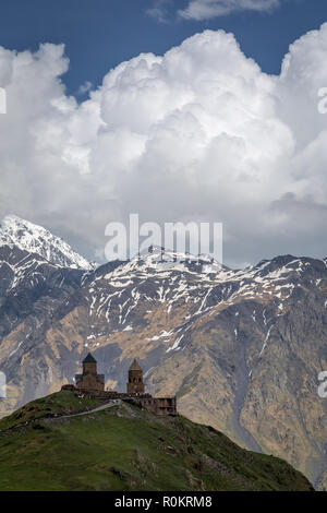 Gergeti Kirche drastisch thront auf einem Hügel im Kaukasus, in Kazbegi, Georgia. Stockfoto