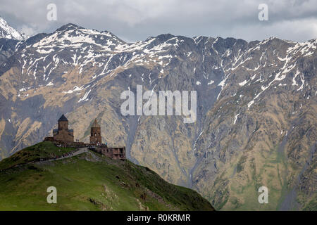 Gergeti Kirche drastisch thront auf einem Hügel im Kaukasus, in Kazbegi, Georgia. Stockfoto