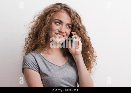 Junge schöne Frau mit Smartphone im Studio, ein Telefonanruf. Stockfoto