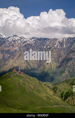 Gergeti Kirche drastisch thront auf einem Hügel im Kaukasus, in Kazbegi, Georgia. Stockfoto