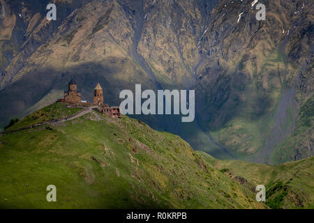 Gergeti Kirche drastisch thront auf einem Hügel im Kaukasus, in Kazbegi, Georgia. Stockfoto