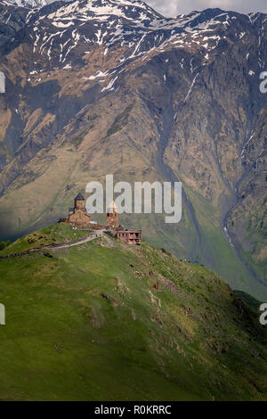 Gergeti Kirche drastisch thront auf einem Hügel im Kaukasus, in Kazbegi, Georgia. Stockfoto