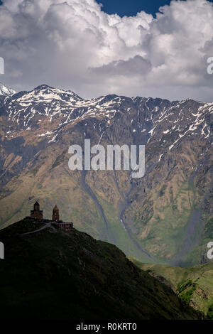 Gergeti Kirche drastisch thront auf einem Hügel im Kaukasus, in Kazbegi, Georgia. Stockfoto