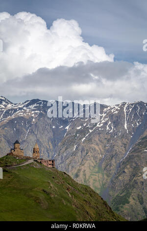 Gergeti Kirche drastisch thront auf einem Hügel im Kaukasus, in Kazbegi, Georgia. Stockfoto