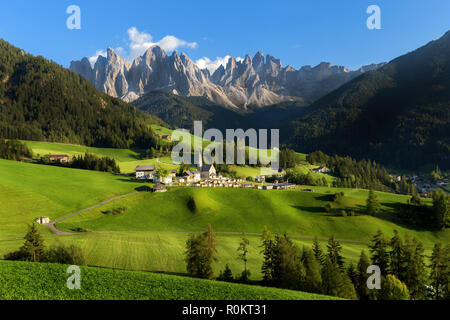 Santa Magdalena Dorf im Val di Funes auf die italienischen Dolomiten. Herbstliche Blick über das Tal, mit bunten Bäumen und Geisler Berg Gruppe auf dem hinterg Stockfoto