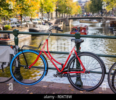 Amsterdam, rotes Fahrrad auf der Brücke geparkt Stockfoto