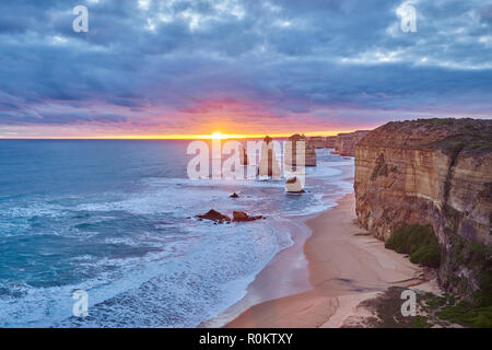 An der felsigen Küste mit den zwölf Aposteln bei Sonnenuntergang, Great Ocean Road, Port Campbell National Park, Victoria, Australien Stockfoto