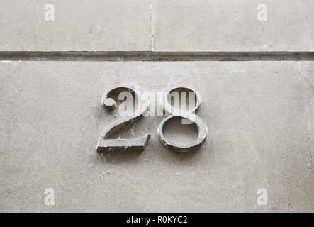 Nummer 28 an der Wand, detail von eine Reihe von Informationen auf einer Straße, Zahlen Stockfoto