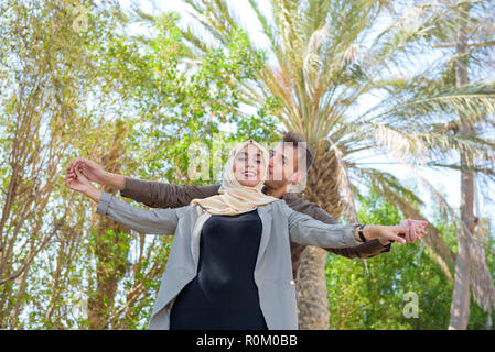 Eine romantische arabische Paar in der freien Landschaft mit Palmen Stockfoto