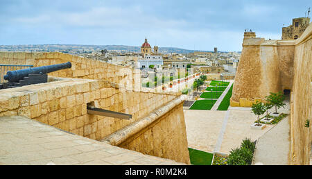 Die vintage Kanone auf der Oberseite des Hl. Johannes Demi-Bastion, mit Blick auf den Garten entlang der covertway, St Michael Bastion von Rabat Festung, St George Parish Stockfoto