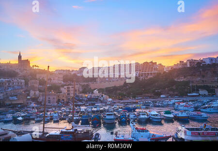 GHAJNSIELEM, MALTA - 15. Juni 2018: Das obere Deck der Fähre ist beste Ort um den Sonnenuntergang über dem Hafen von Mgarr, voll mit alten Fischerbooten eine zu beobachten Stockfoto