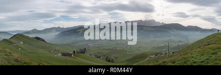 Panorama Landschaft Blick auf die wunderschöne Region Appenzell in der Schweiz mit seinen sanften Hügeln und Farmen und den Alpstein Berge hinter und ein einsames Stockfoto