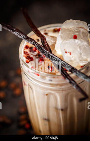 In der Nähe von hohen Glas Eiskaffee Latte mit rosa Pfeffer und Vanille Stockfoto