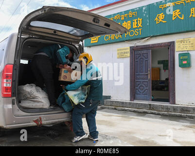 (181106)-BEIJING, November 6, 2018 (Xinhua) - Motorrad Kurier Gesang Cering (R) und einen Nahestehenden postpakete an der China Post Filiale in Pumaqangtang Township von Nagarze County entladen, der Südwesten Chinas Autonomen Region Tibet, 27. Juli 2018. China's Kurier einen stetigen Wachstum in den ersten neun Monaten dieses Jahres nach Angaben der staatlichen Post Präsidium gegeben. Der Sektor geharkt in 424.63 Milliarden Yuan (etwa 61 Milliarden US-Dollar) der Umsatz von Januar bis September um 24 Prozent über Vorjahr, mit Paketen geliefert in Höhe von 34.74 Mrd. Euro. (Xinhua/Li Er) (clq) Stockfoto