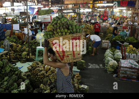 Quezon City, Philippinen. 6 Nov, 2018. Ein Arbeitnehmer trägt einen Korb voller Bananen in einem Markt, in Quezon City, Philippinen, Nov. 6, 2018. Die Inflation in den Philippinen mit 6,7 Prozent im Oktober, 2018 gefestigt, der philippinische Statistik behörde (PSA) sagte am Dienstag. Credit: rouelle Umali/Xinhua/Alamy leben Nachrichten Stockfoto