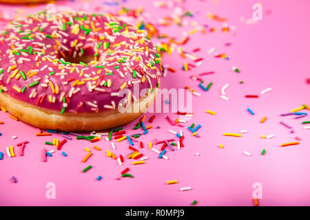 Donuts auf einem rosa Hintergrund. Köstliches Dessert. Stockfoto