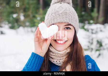 Junge Frau mit Herz im Winter schnee Wald. Liebe Konzept. Valentinstag Hintergrund. Stockfoto