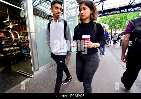 Asiatische Paar mit Takeaway Kaffee und Handy, Borough Market, London, England, UK. Stockfoto