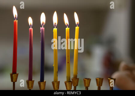 Bunte Chanukah Kerzen in einem goldenen menorah Stockfoto