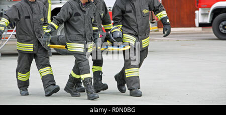 Italia, Italien, 10. Mai 2018: Italienische porter Feuerwehrmänner transport einer auf der Bahre während einer praktischen Rescue Übung verletzt Stockfoto