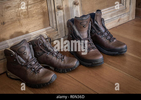 Zwei Paare aus Leder Wanderschuhe auf einem Holzboden. Stockfoto