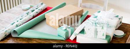 DIY Geschenkverpackung. Schönen nordischen Weihnachten Geschenke auf Holztisch. Weihnachten folierstation Konzept Banner. Stockfoto