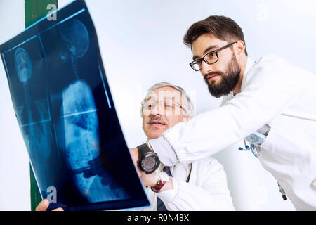 Ärzte Prüfung eines X-ray des Körpers einer Frau Stockfoto