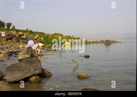 Ayoung paar Paddeln im Wasser am westlichen Ufer des Sees von Galiläa nördlich von Tiberias auf eine heiße diesigen Nachmittag. Stockfoto