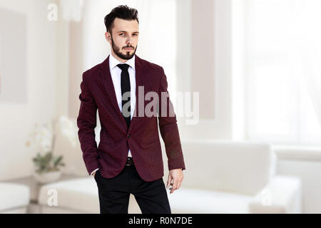Schöne und elegante modische Mann oder Geschäftsmann im luxuriösen Innenraum von einem hellen Zimmer POSING (gemischt). Stockfoto