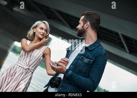 Romantisches date im Freien. Junges Paar zu Fuß auf der Straße halten sich an den Händen an jedem anderen freudigen close-up Stockfoto