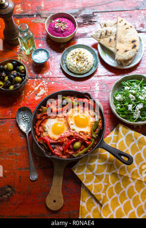 Im Nahen und Mittleren Osten Gericht Shakshuka mit Feta Rucola, Hummus, Oliven und gerösteten Fladenbrot Stockfoto