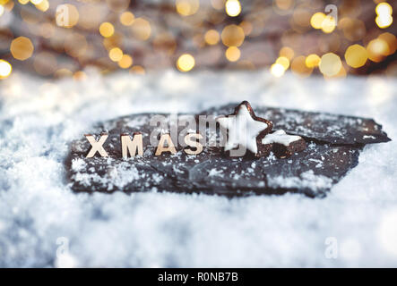 Weihnachtsdekoration mit Lebkuchen Sterne und Holz- XMAS Buchstaben in den Schnee Stockfoto