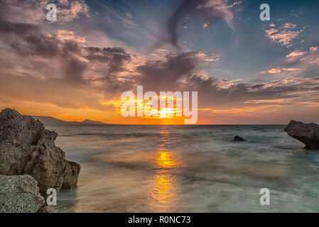 Lange Belichtung photograhy am felsigen Kato Petres Strand Landschaft in der Abenddämmerung. Rhodos, Griechenland Stockfoto