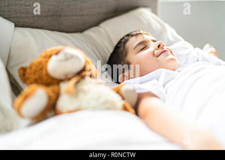 Ein kleiner Junge im Bett schlafen und träumen Stockfoto