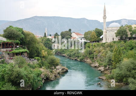 Mostar, Bosnien und Herzegowina - 15. September 2018: Neretva Fluss fließt durch Mostar. Am Ufer können Sie Fragmente der Stadt. Stockfoto