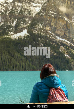 LAKE LOUISE, AB, Kanada - Juni 2018: Person allein sitzen mit Blick auf Lake Louise in Alberta, Kanada, Stockfoto