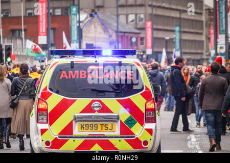 CARDIFF, WALES - NOVEMBER 2018: Rettungswagen von St. John Cymru, der durch die Menschenmassen von Rugby-Anhängern im Stadtzentrum von Cardiff fährt Stockfoto