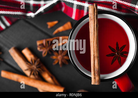 Weihnachten Glühwein mit Gewürzen in rot Tasse auf Holz- Hintergrund. Stockfoto