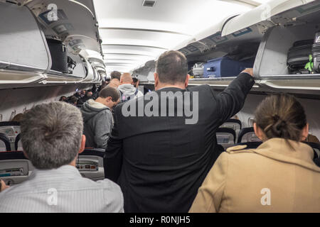 Passagiere, die darauf warten, zu, aussteigen, und, Ihre, Gepäck, aus, Overhead, Fächer, an, Manchester, Flughafen, nach, Ankunft, ein, eine, Brussels Airlines, Flug, Stockfoto